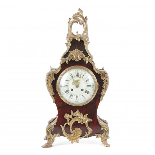 In wood and Boulle style marquetry with faux-tortoiseshell and bronze. Paris clockwork. In working order. With key and pendulum. Small losses. 51 x 25 x 14,5 cm.