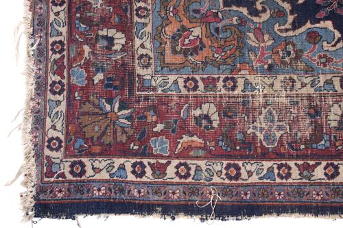 PERSIAN CARPET IN REDDISH AND BLUISH TONES.