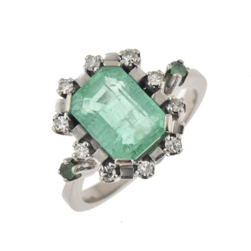 Rosette ring with emerald bordered with diamonds.